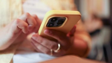 Kafede kahve içerken cep telefonu kullanan mutlu güzel bir kız. Cep telefonu tutan ve akıllı telefona bakan 30 'lu yaşlardaki güzel sarışın bir kız. Yüksek kaliteli FullHD görüntüler