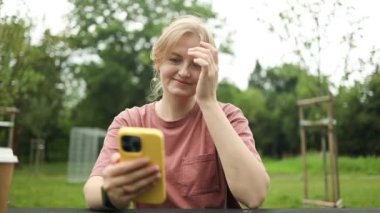 Beyaz tenli çekici bir kadın şehirde yürürken telefonla konuşuyor. Güzel kadın turist, akıllı telefon kullanarak tek başına seyahat ediyor. Tatilde iyi vakit geçiriyor. 