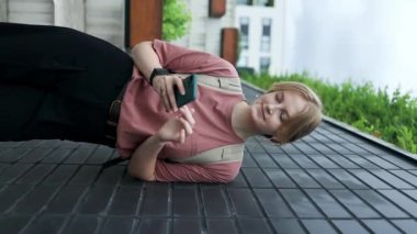 Akıllı telefon kullanan mutlu beyaz bir öğrenci. Sırt çantalı, dışarıda mutlu mesut yürüyen, cep telefonuyla gülümseyen, daktilo ve telefonla konuşan 30 'lu yaşlarda bir kadın.