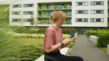 Güzel kız öğrenci cep telefonu kullanıyor eğitim teknolojisi uygulamalarını kullanıyor dışarıda duran akıllı telefonlu mesajlara bakıyor. Mobil çevrimiçi uygulama kavramı. Yüksek kalite FullHD
