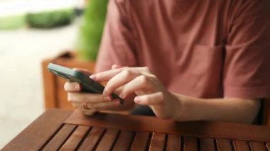 Genç kadın ya da genç kız elleri cep telefonu tutarken parmaklarına dokunuyor boş beyaz ekran, şehir kafesinde sosyal medya uygulaması reklamı için boş ekran. Mobil uygulama teknolojisi kavramı 