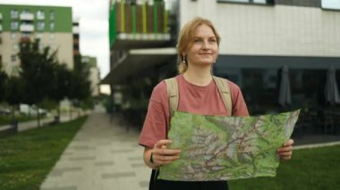 Canlı turist kadın elinde harita ile yeni bir şehri keşfediyor. Polonya 'da elinde kağıt harita tutan bir kadın.. 