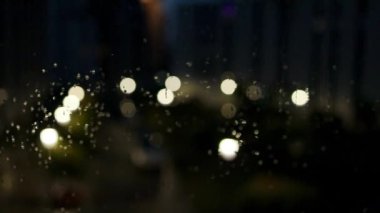 Dışarıdaki aynaya bakan arabanın camına eriyen kar damlaları düşer. Kış gecesi şehir manzarası. Yüksek kaliteli FullHD görüntüler