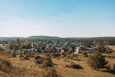 Dağlarda güzel bir yaz gündoğumu. Dalgalı tarlalar ve köy. Yay tarlaları ve ufukta yaşlı meşe ağacı ve köy arasında kırsal çakıl yolu olan bir panorama. Yüksek kalite fotoğraf