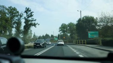 Araba penceresi yolu gösteriyor. Etrafı tarlalarla, ağaçlarla, temizliklerle çevrili. Araba penceresinden akşam manzarası, arka plana doğru geçiş. 