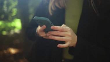 İş kadını elleri gözlüklü Central City caddesinde yürüyor ve telefonunu bir alışveriş merkezinin arka planında kullanıyor..