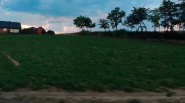 Şehirlerin dışındaki manzarayı değiştiren manzaralı bir tren yolculuğu. Kırsal kesimde, hareket halindeki bir arabanın yan camı. Otomobil manzaralı tarım arazisi çayırları ve ormanlar. 