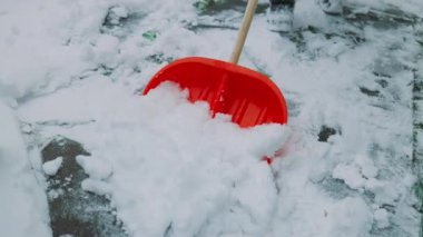 Bir kürekle karı temizle. Adam kar kürekleri kürekliyor. Elde kar küreği. Kışın etrafı temizliyorum. Kar küreği. Yüksek kaliteli FullHD görüntüler