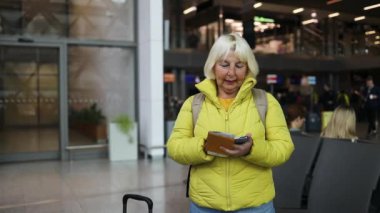 50 'li yaşlarda şık, güzel bir kadın Avrupa' da valiziyle geziyor. Güz kıyafetleri sokak tarzında. Yüksek kalite fotoğraf