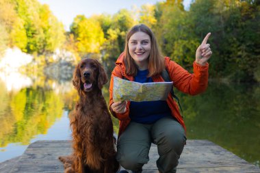 Dağ gölünde yürüyüş yapan 30 'lu yaşlarda mutlu kadın yürüyüşçüler. İrlandalı köpekli bir kadın haritaya bakıyor ve plan yapıyor ya da kayboluyor. Polonya. Yüksek kalite fotoğraf
