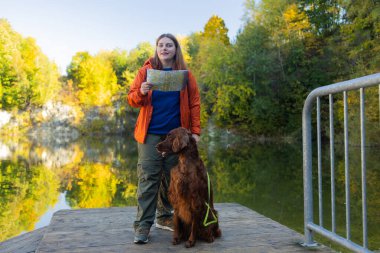 Dağ gölünde yürüyüş yapan 30 'lu yaşlarda mutlu kadın yürüyüşçüler. İrlandalı köpekli bir kadın haritaya bakıyor ve plan yapıyor ya da kayboluyor. Polonya. Yüksek kalite fotoğraf