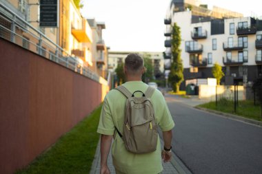 Genç adam trafik ışıklarının karşıdan karşıya geçmesini bekliyor.