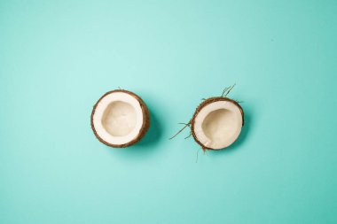 Mavi arka planda olgun hindistan cevizi. Pop sanat tasarımı, yaratıcı yaz konsepti. Pankart. Minimum düzlükte hindistan cevizinin yarısı. Yüksek kalite fotoğraf