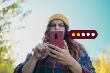Müşteri Deneyimi Konsepti. Çok iyi. Şirketin reytingini arttırmak için ikon iki yıldız sembollü cep telefonu kullanan kişi. Yüksek kalite fotoğraf