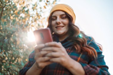 Çekici bir kadının portresi. Cep telefonuyla şehir sokaklarında gülüyor. Yüksek kalite fotoğraf