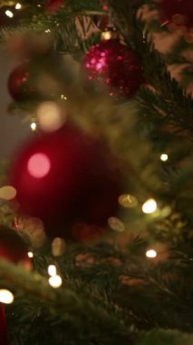 Mutlu yıllar Noel ağacı, arka plandaki kırmızı cam top ile süslenir. Kış tatilinde aile tatili için yanıp sönen ampuller. Festival havası. Noel.. 