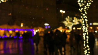 Mutlu Noeller. Genç ve yaşlı insanlardan oluşan bir grup, sokak fuarında sıcak bir kış akşamında yürüyen arkadaşlar. Odaklanmamış sokak. Kış tatili kavramı, Noel, gelenekler, açık hava fuarı