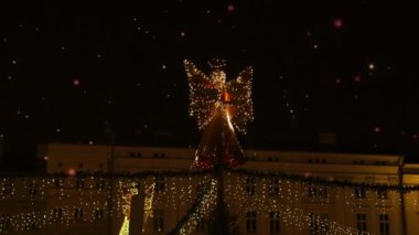 Polonya, Krakow 'dan meşale tutan bir melek şeklinde Noel ışıkları süslemesi. Odaklanmamış sokak. Kış tatili kavramı