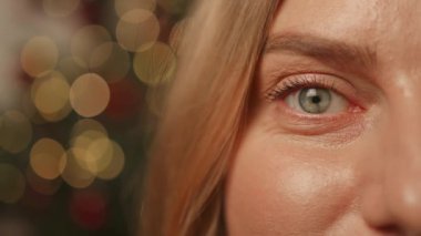 Neşeli, gülümseyen, poz veren genç bir kadın. Kameraya bak. Sade pastel bej arka planda göz kırp. Noel tatili kavramı 