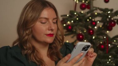 Güzel, rüya gibi genç bir kadın akıllı telefon mesajlarıyla süslenmiş Noel ağacının yanında oturuyor. Arkadaşlarını uzaktan tebrik ediyor. Boş zaman, Xmas arifesinde modern teknoloji kullanımı