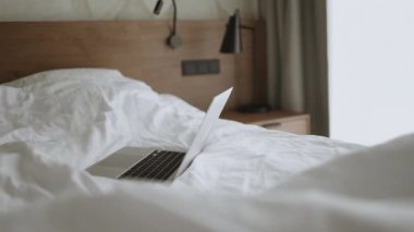 Laptop yatağın üstünde. Evde iş var. Yatak odasında çalış. Laptopla yatakta dinlen. Yüksek kaliteli FullHD görüntüler
