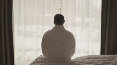 Yakışıklı genç adam sabah uyanır, yatak odasında uzanır ve yataktan kalkar, iş fırsatlarına, başarılara, maceralara hazırdır. Yüksek kaliteli FullHD görüntüler