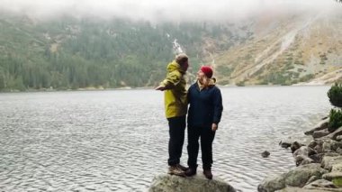 Doğadaki ilk buluşmada birlikte eğlenen iki turist dağ gölünde yamaçlarda yürüyorlar.. 