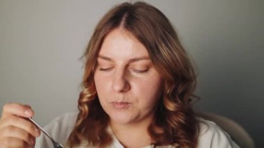 Evdeki mutfakta sağlıklı bir kahvaltı yapan güzel bir bayanın yüksek kaliteli FullHD görüntüsü.