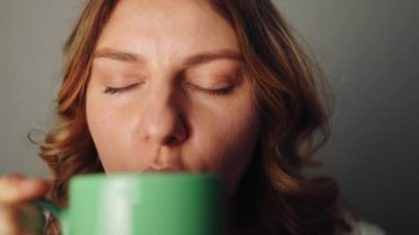 Kafkasyalı genç bir kadın kahve içip güneşin doğuşunu ve manzarasını seyrediyor. Yüksek kaliteli FullHD görüntüler