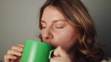 Kafkasyalı genç bir kadın kahve içip güneşin doğuşunu ve manzarasını seyrediyor. Yüksek kaliteli FullHD görüntüler