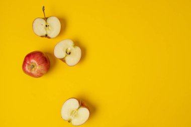 Düz kompozisyon ve sarı arka planda birçok kırmızı elma vardı. Mesaj için yer var. Yüksek kalite fotoğraf