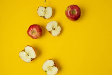 Düz kompozisyon ve sarı arka planda birçok kırmızı elma vardı. Mesaj için yer var. Yüksek kalite fotoğraf