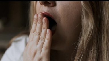 Ağzı açık esneyen yorgun kadının dinlenmeye ihtiyacı var, uykusuzluktan uyanamıyor. Zincir reaksiyonu. Güzel bir kadının uyanıp esnediği bir yere. Yüksek kaliteli FullHD görüntüler