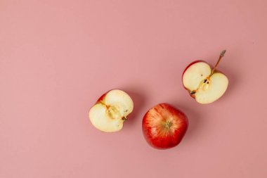 Yeşil kırmızı elma, yarım elma ve pembe arka planda çeyrek elma. Üst düzey, sağlıklı gıda konsepti. Üst Manzara. Yüksek kalite fotoğraf
