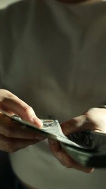  Adam bize 100 dolarlık banknotları sayarak para veriyor. Tasarruf kavramı. Yüksek kaliteli FullHD görüntüler