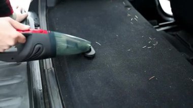 Araba süpürgesinin detayları. Kirli araba için elektrikli süpürge kullanan profesyonel kırpılmış erkek işçi. Otomobil servisi sürücü koltuğunu temizliyor, temizlik ve süpürme konsepti. Yüksek