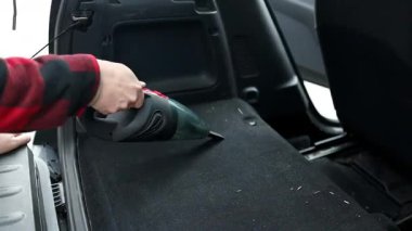 Araba süpürgesinin detayları. Kirli araba için elektrikli süpürge kullanan profesyonel kırpılmış erkek işçi. Otomobil servisi sürücü koltuğunu temizliyor, temizlik ve süpürme konsepti. Yüksek