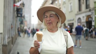 Yaşlı bir kadın şehirde dolaşırken dondurma külahı yiyor. Güneşli bir günde tatlı bir ziyafetin tadını çıkarıyor. Şapka ve rahat giysiler giyiyor..