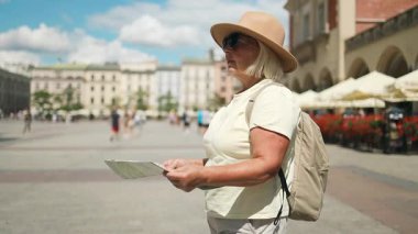 Şapkalı ve sırt çantalı 60 'ların Kafkasyalı son sınıf öğrencisi Polonya' nın Krakow şehrinin merkezini keşfediyor. Elinde bir harita tutuyor, güneşli bir günde tarihi sokakları geziyor.