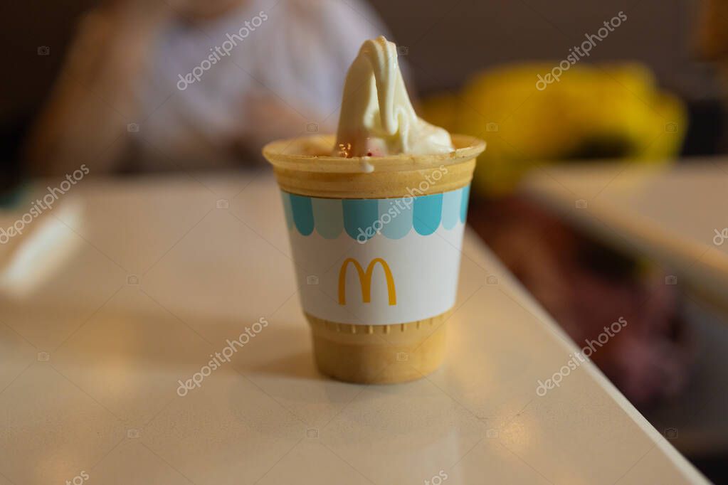 Krakow, Poland - March 26, 2025: close-up image of a McDonalds ice cream cone served in a disposable cup, showcasing the creamy texture and iconic brand design. Ideal for food-related or brand