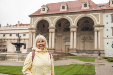 Çek Cumhuriyeti 'nin Prag kentindeki Wallenstein Sarayı' ndaki dekoratif bir parkta birçok heykelle süslenmiş dekoratif bir sokak boyunca gezen kadın turist görülüyor.