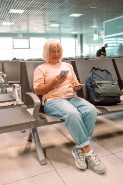 Qr code, check in and man with a phone for a ticket, airplane booking and information at airport. Travel, website and hand of a businessman reading a barcode on a mobile for a work trip or vacation