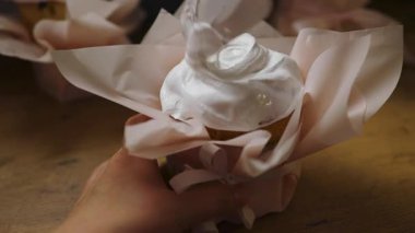 Paskalya bayramında el süslemesi ya da yumuşak kağıt ambalajında beyaz kremalı tatlı çörekler. Tatil içeriği, tarifler ve geleneksel tarifler için mükemmel ev yapımı bir yemek sahnesi.