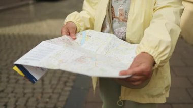 Polonya 'nın eski Krakow kasabasını keşfederken elinde şehir haritası olan son sınıf bir kadının yakın çekimi. Tarihi bir Avrupa 'da macera, keşif ve bağımsız navigasyonu simgeleyen samimi bir seyahat anı