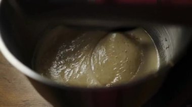 Elektrikli mikser hamuru ya da kremayı paslanmaz çelik bir kaseye yakın plan. Pişirme hazırlığında klasik bir adım, yemek dersleri, yemek tarifleri, yemek blogları ve yavaş yaşam içeriği için ideal.