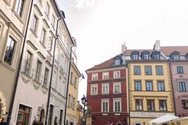 Polonya 'nın tarihi Varşova kasabasında geleneksel çok renkli binalar. Parlak cepheli ve yurt pencereli klasik Avrupa mimarisi. Seyahat, miras ve kentsel görseller için harika..