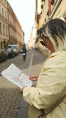 Polonya 'nın eski Krakow kasabasını keşfederken elinde şehir haritası olan son sınıf bir kadının yakın çekimi. Tarihi bir Avrupa 'da macera, keşif ve bağımsız navigasyonu simgeleyen samimi bir seyahat anı