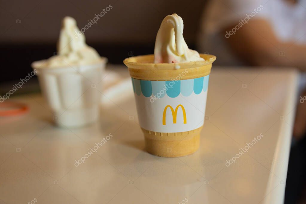Krakow, Poland - March 26, 2025: close-up image of a McDonalds ice cream cone served in a disposable cup, showcasing the creamy texture and iconic brand design. Ideal for food-related or brand