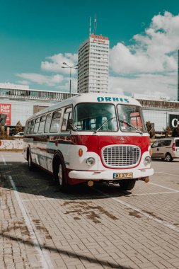 Varşova, Polonya - 3 Eylül 2023 Modern gökdelenlerle çevrili, güneşli bir günde kırmızı, mavi ve beyaz renkli otobüslerle arka arkaya park edilmiş. Nostaljik tasarım ve araçların koyu renkleri