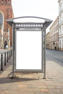 Krakow 'daki Boş Otobüs Durağı Reklam Çerçevesi. Krakow 'da kaldırımlı bir caddedeki modern bir otobüs durağında yüksek kaliteli fotograf boş reklam panosu duruyor. Boş çerçeve yeni bir reklam için hazır.